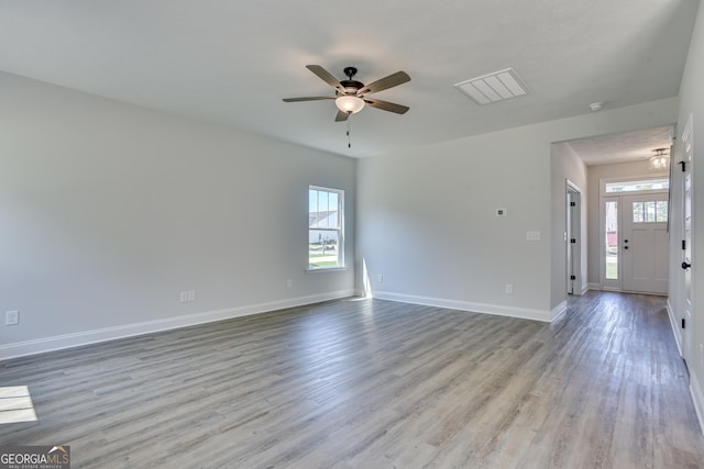 unfurnished living room featuring light wood-style floors, baseboards, and a ceiling fan