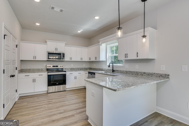 kitchen with pendant lighting, visible vents, appliances with stainless steel finishes, white cabinets, and a peninsula