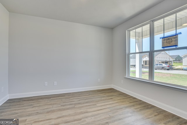 empty room with light wood-style flooring and baseboards