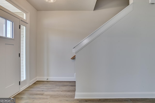 entryway with baseboards, a wealth of natural light, and light wood-style floors