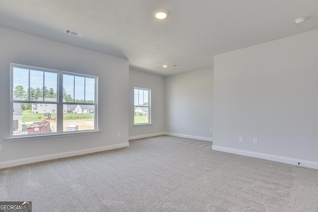 spare room with light carpet, recessed lighting, visible vents, and baseboards