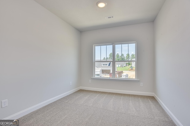 carpeted empty room featuring visible vents and baseboards