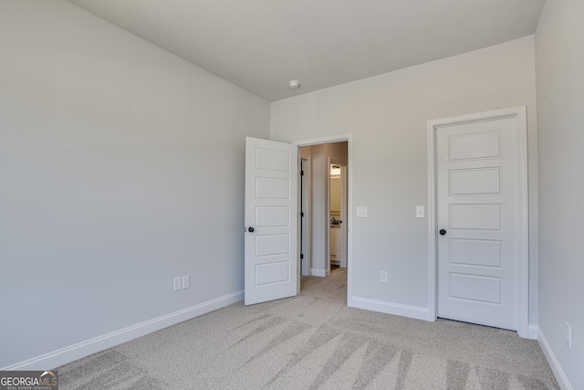 unfurnished bedroom with light carpet and baseboards