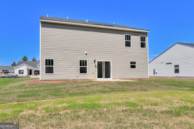 back of property featuring a lawn