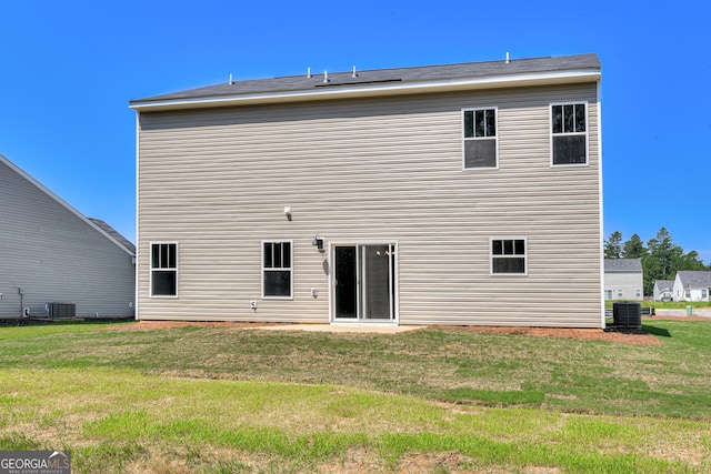 back of property with a lawn and central AC unit