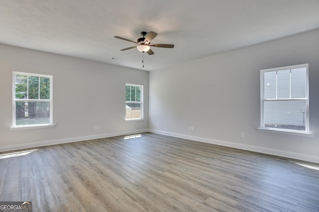 empty room featuring baseboards, ceiling fan, visible vents, and light wood finished floors