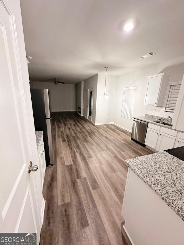 kitchen featuring stainless steel appliances, visible vents, white cabinets, open floor plan, and pendant lighting