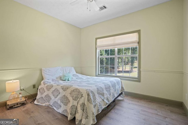 bedroom featuring light wood-style floors, visible vents, ceiling fan, and baseboards