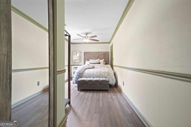 unfurnished bedroom featuring ceiling fan, ornamental molding, wood finished floors, and baseboards