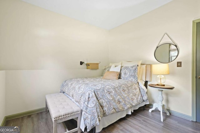 bedroom with dark wood finished floors and baseboards