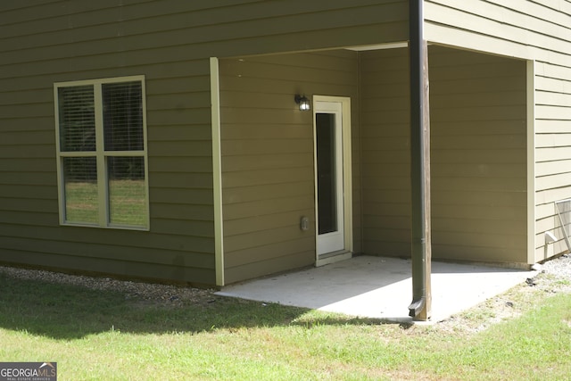 doorway to property featuring a patio area and a yard