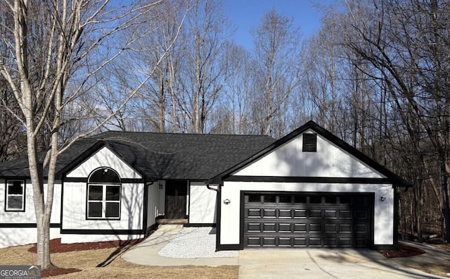 view of front of home featuring a garage, concrete driveway, and a shingled roof