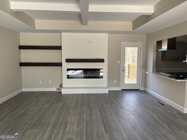 unfurnished living room featuring dark wood-style floors, a fireplace, and baseboards