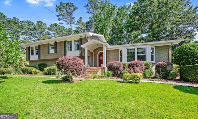 split level home with brick siding and a front yard