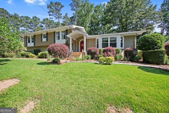 tri-level home with a front yard and brick siding