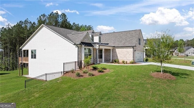 view of front of home with an attached garage, fence, a front lawn, and concrete driveway