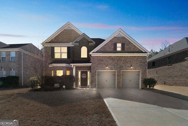 traditional-style house featuring concrete driveway, brick siding, and an attached garage