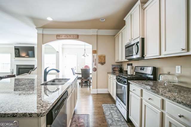 kitchen featuring white cabinets, stainless steel appliances, a sink, and an island with sink