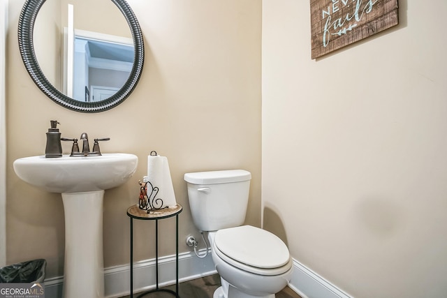 bathroom with baseboards, a sink, and toilet