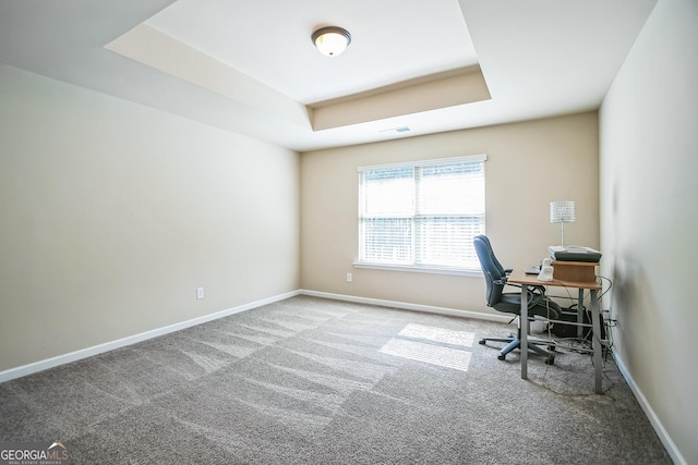 carpeted home office with baseboards, visible vents, and a raised ceiling