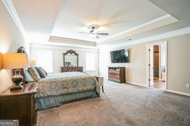 bedroom with crown molding, carpet floors, a raised ceiling, and baseboards