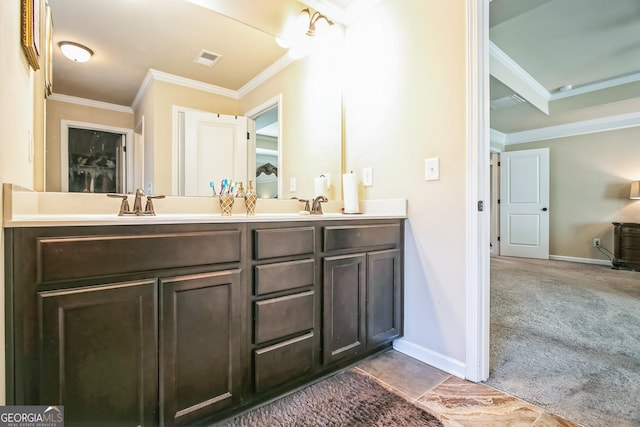 bathroom with double vanity, ornamental molding, visible vents, and baseboards