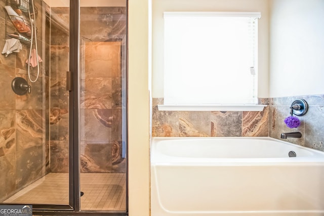 bathroom featuring a garden tub and a shower stall