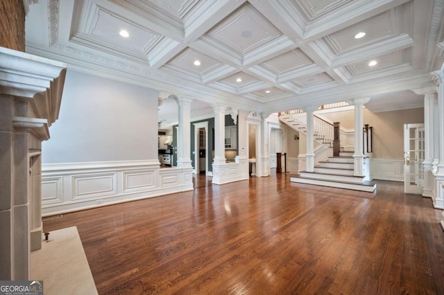 unfurnished living room featuring crown molding, beamed ceiling, stairway, and ornate columns