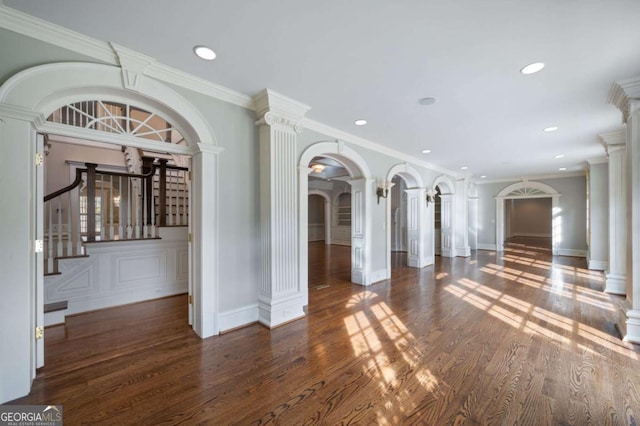 unfurnished living room with dark wood-style floors, decorative columns, arched walkways, and recessed lighting