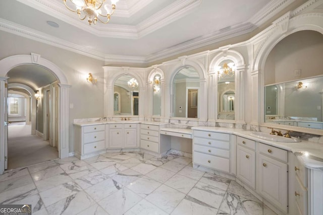 full bathroom featuring ornamental molding, a raised ceiling, a notable chandelier, and vanity