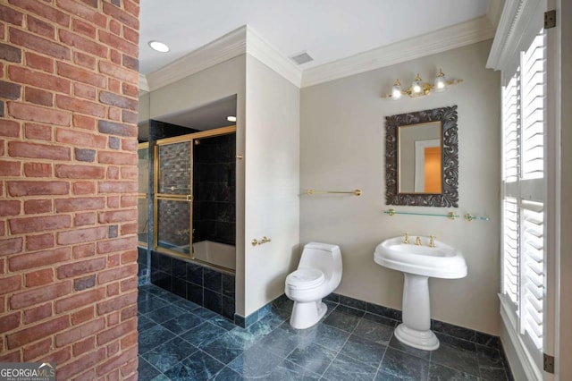 bathroom with tiled shower / bath, ornamental molding, toilet, and baseboards