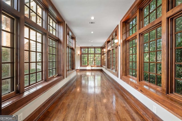 corridor featuring baseboards, visible vents, wood finished floors, and recessed lighting