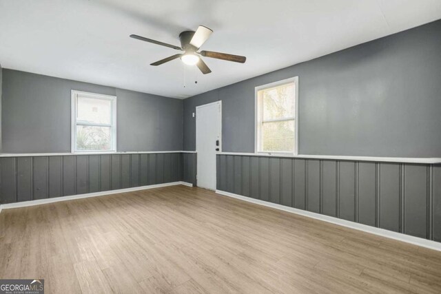 391 Mount Zion Rd SW, Atlanta, GA 30354 - empty room featuring plenty of natural light, wainscoting, light wood-type flooring, and a ceiling fan