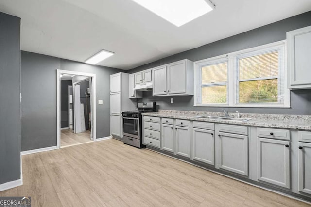 391 Mount Zion Rd SW, Atlanta, GA 30354 - kitchen with stainless steel gas range oven, baseboards, light wood-type flooring, under cabinet range hood, and a sink