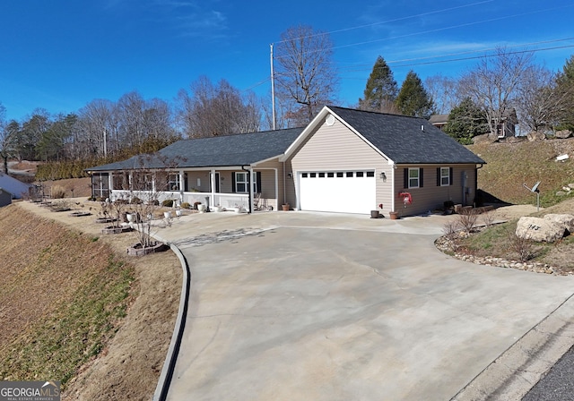 ranch-style house featuring an attached garage, driveway, a porch, and roof with shingles