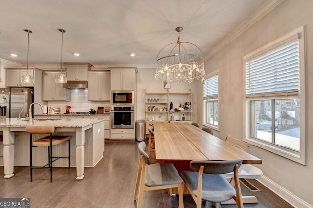 dining space featuring dark wood-style floors, crown molding, and baseboards