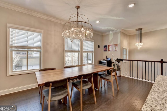 dining space featuring dark wood-style floors, crown molding, baseboards, and an inviting chandelier