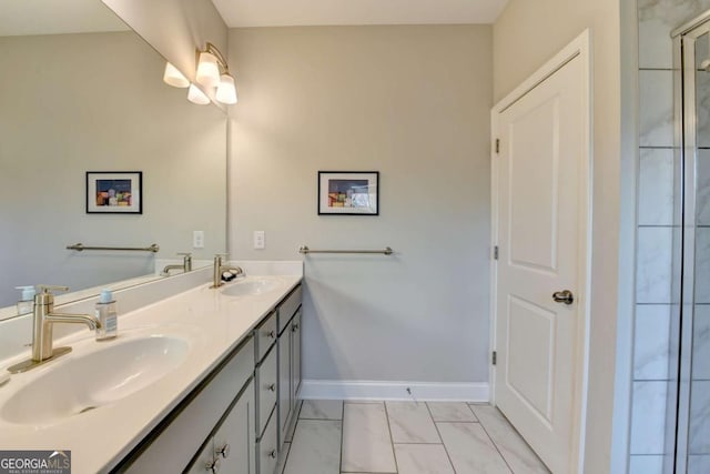 full bathroom with marble finish floor, a sink, baseboards, and double vanity