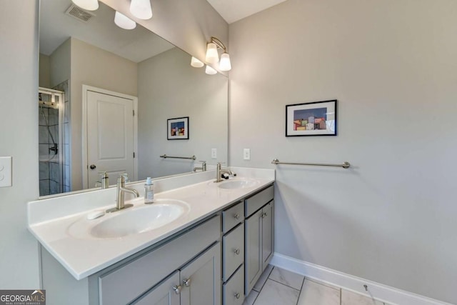 full bath featuring double vanity, a sink, visible vents, and baseboards