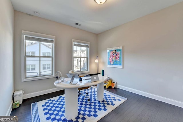 office space featuring dark wood-style flooring, visible vents, and baseboards