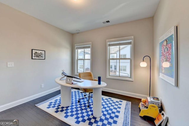 home office with dark wood-style flooring, visible vents, and baseboards