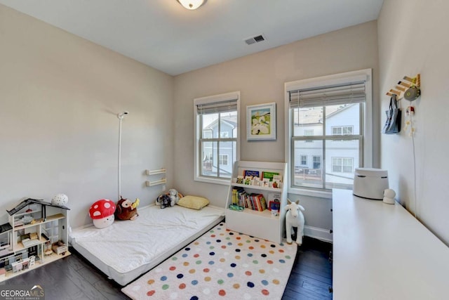 bedroom featuring dark wood-style flooring, multiple windows, visible vents, and baseboards