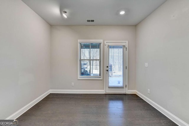 doorway featuring dark wood finished floors, visible vents, and baseboards