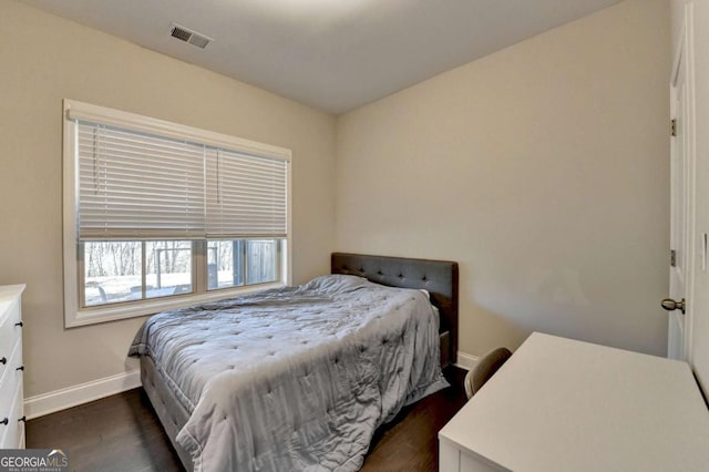 bedroom with dark wood-style flooring, visible vents, and baseboards