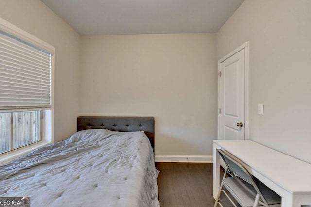 bedroom with dark wood-style flooring and baseboards