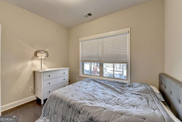 bedroom with baseboards, visible vents, and dark wood-style flooring