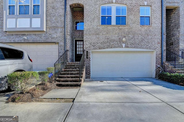 view of front of property featuring concrete driveway, brick siding, and an attached garage