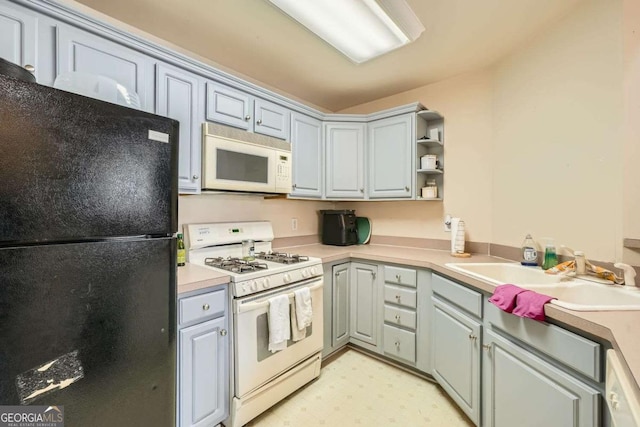 kitchen featuring white appliances, a sink, light countertops, gray cabinets, and light floors