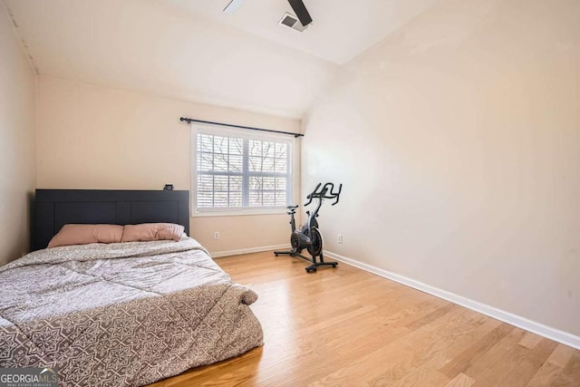 bedroom featuring lofted ceiling, ceiling fan, light wood-style flooring, visible vents, and baseboards