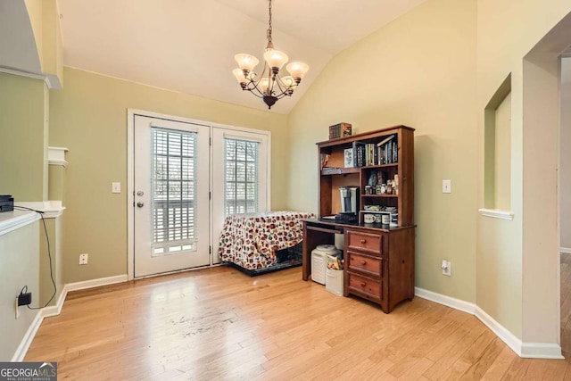 office space with light wood-style floors, vaulted ceiling, baseboards, and an inviting chandelier